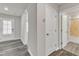 Hallway featuring wood-look flooring, neutral paint, and doors leading to a bedroom and bathroom at 1723 Starlit Sky Ln, Cary, NC 27519
