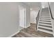 Hallway view with wood-look flooring, neutral paint, and stairway access to additional floors at 1723 Starlit Sky Ln, Cary, NC 27519