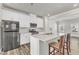 Beautiful kitchen with white cabinets, stainless steel appliances, island bar, and wood grain flooring at 1723 Starlit Sky Ln, Cary, NC 27519