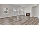 Cozy living room with a fireplace, wood grain floors, and large windows providing plenty of light at 1723 Starlit Sky Ln, Cary, NC 27519