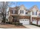 Charming townhome featuring a stone facade, two-car garage, and well-maintained landscaping at 1800 Pierre Pl, Apex, NC 27502