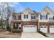 Charming townhome featuring a stone facade, two-car garage, and well-maintained landscaping at 1800 Pierre Pl, Apex, NC 27502