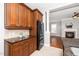View of kitchen featuring granite countertops, and dark cabinets leading into living room at 1800 Pierre Pl, Apex, NC 27502