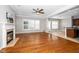 Spacious living room with hardwood floors, fireplace, plantation shutters, and open access to the kitchen at 1800 Pierre Pl, Apex, NC 27502