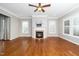 Bright living room featuring hardwood floors, fireplace, plantation shutters, and ceiling fan at 1800 Pierre Pl, Apex, NC 27502