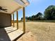 Covered back patio with wooden posts, ceiling fan, and large backyard at 20 Eagle Crest Court Way # Holly Farmhouse, Lillington, NC 27546