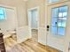 Hallway with wood-look floors leading to a bathroom and the front entry at 20 Eagle Crest Court Way # Holly Farmhouse, Lillington, NC 27546