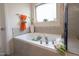 Relaxing bathroom with a soaking tub, tile accents, and a window at 207 Kinnakeet Dr, Durham, NC 27704