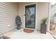 Close-up of the front door with decorative wreath, stylish doormat, and attractive potted plant, creating curb appeal at 207 Kinnakeet Dr, Durham, NC 27704