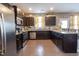 Functional kitchen with dark cabinets, stainless steel appliances, wood floors, and granite countertops at 207 Kinnakeet Dr, Durham, NC 27704