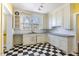 Bright kitchen featuring checkerboard flooring, white cabinets, and a stainless steel sink at 2110 Cokey Rd, Rocky Mount, NC 27801