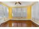 Sunlit living room with hardwood floors, white curtains, and ample natural light filtering through large windows at 2110 Cokey Rd, Rocky Mount, NC 27801