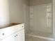 Bright bathroom featuring a white vanity and new white shower with built-in shelves at 212 Fast Pitch Ln, Four Oaks, NC 27524