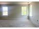 Light-filled bedroom with two large windows, electrical outlets, and base trim, awaiting flooring and décor at 212 Fast Pitch Ln, Four Oaks, NC 27524