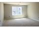 Empty bedroom featuring large windows and natural light at 212 Fast Pitch Ln, Four Oaks, NC 27524
