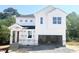 Two-story home showcasing a bright white exterior and an attached two-car garage awaiting finishing touches at 212 Fast Pitch Ln, Four Oaks, NC 27524