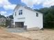 Side view of a new construction home showing white siding, stone accents and two-car garage at 212 Fast Pitch Ln, Four Oaks, NC 27524