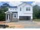 New two-story home with stone accents, white siding, and an attached two-car garage at 212 Fast Pitch Ln, Four Oaks, NC 27524