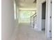 Bright living room featuring large windows, staircase, and open doorway, showcasing the home's unfinished potential at 212 Fast Pitch Ln, Four Oaks, NC 27524