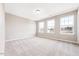 Spacious bedroom with plush carpet and three large windows providing natural light at 212 Wildwood Ln, Graham, NC 27253