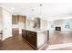 Open kitchen with stainless steel appliances, a center island, and seamless flow to the living area at 212 Wildwood Ln, Graham, NC 27253