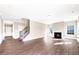 Open-concept living room with a cozy fireplace, hardwood floors, and ample natural light at 212 Wildwood Ln, Graham, NC 27253