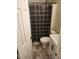 Bright bathroom featuring a toilet, new vanity, and shower with a dark plaid curtain at 216 Clayton St, Rocky Mount, NC 27803