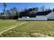 Expansive grassy backyard featuring a white fence and treeline, offering privacy at 24 Heatherglenn Cir, Princeton, NC 27569
