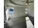 Sunlit primary bedroom with a tray ceiling, a ceiling fan, and plush carpeting for comfort at 24 Heatherglenn Cir, Princeton, NC 27569