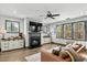 A cozy living room with a stone fireplace, mounted TV, ceiling fan, and ample windows for natural light at 2504 Georgianna Dr, Wake Forest, NC 27587