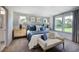 This bedroom is decorated with blue accents, a neutral bench, natural light, and ensuite bathroom access at 268 Sweetbay Tree Dr, Wendell, NC 27591