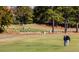 Scenic view of golfers on the community golf course, featuring lush green fairways and mature trees at 270 Sweetbay Tree Dr, Wendell, NC 27591