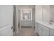 A new bathroom boasts gray tiled floors, dual vanities, and a walk-in shower with glass door at 277 Gregory Village Dr, Lillington, NC 27546