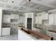 Unfinished kitchen featuring white cabinets and drywall, showcasing a spacious layout awaiting final touches at 277 Gregory Village Dr, Lillington, NC 27546