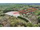 Aerial view of wooded land parcel for sale near a pond surrounded by mature trees at 292 Choice Trl, Pittsboro, NC 27312