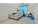 A simple bedroom featuring light wood floors and a window with floral curtains at 3137 Groveshire Dr, Raleigh, NC 27616