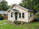 Angle view of a quaint yellow bungalow featuring a cozy front porch and a well-maintained lawn at 318 Mcmasters St, Chapel Hill, NC 27516