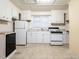 Well-lit kitchen featuring white cabinetry, efficient appliances, and clean tile flooring at 318 Mcmasters St, Chapel Hill, NC 27516