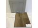 Close-up of home construction materials, including stone gray cabinet, quartz countertop, and luxury vinyl flooring at 328 Chesapeak Commons St # 142, Garner, NC 27529