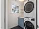 Modern laundry room with stacked washer/dryer, storage, window, and overhead lighting at 35 Rogerson Dr, Chapel Hill, NC 27517