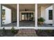 Inviting covered back porch featuring brick pavers, stone fireplace, and comfortable seating at 3513 Eden Croft Dr, Raleigh, NC 27612