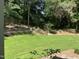 Backyard featuring a lush lawn, landscaping with flowers, and privacy trees at 3513 Eden Croft Dr, Raleigh, NC 27612