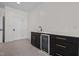 Bonus room beverage bar with mini fridge, dark cabinetry, marble countertops, and stainless steel sink at 3513 Eden Croft Dr, Raleigh, NC 27612
