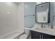 Renovated bathroom with herringbone tile backsplash, marble vanity, and modern fixtures at 3513 Eden Croft Dr, Raleigh, NC 27612
