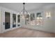 Bright dining room with chandelier, large windows, and glass doors leading to an outdoor space at 3513 Eden Croft Dr, Raleigh, NC 27612