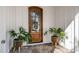Close up of stunning wooden front door with glass, white trim, stone floor, and decorative plants at 3513 Eden Croft Dr, Raleigh, NC 27612