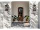 Close up of beautiful wood front door framed by black lanterns and white brick, potted plants flanking entrance at 3513 Eden Croft Dr, Raleigh, NC 27612