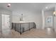 Open hallway with hardwood floors, modern chandelier, and staircase access with black railings at 3513 Eden Croft Dr, Raleigh, NC 27612