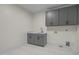 A well-equipped laundry room with upper cabinets, a utility sink, and ample countertop space at 3513 Eden Croft Dr, Raleigh, NC 27612