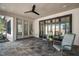 Cozy covered patio with tiled floor, ceiling fan, and comfortable seating area for outdoor enjoyment at 3513 Eden Croft Dr, Raleigh, NC 27612